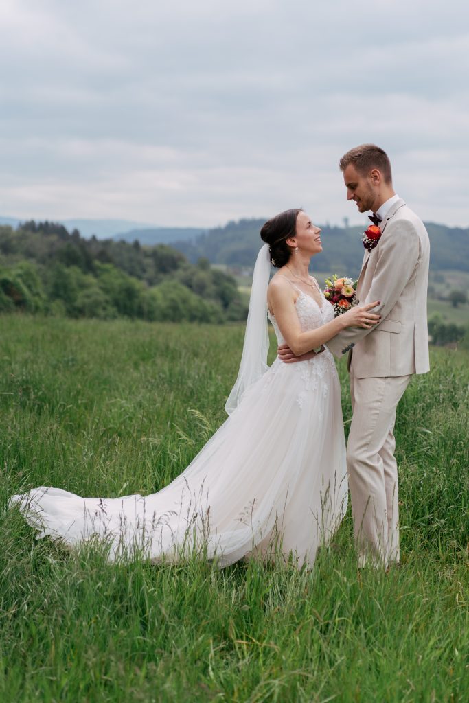 Brautpaar auf einer Bergwiese mit rotem Käfer – Hochzeitsfotografie Mosipictures