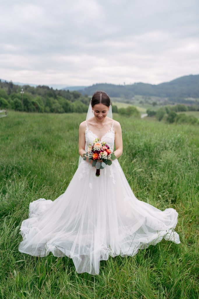 Brautpaar auf einer Bergwiese mit rotem Käfer – Hochzeitsfotografie Mosipictures