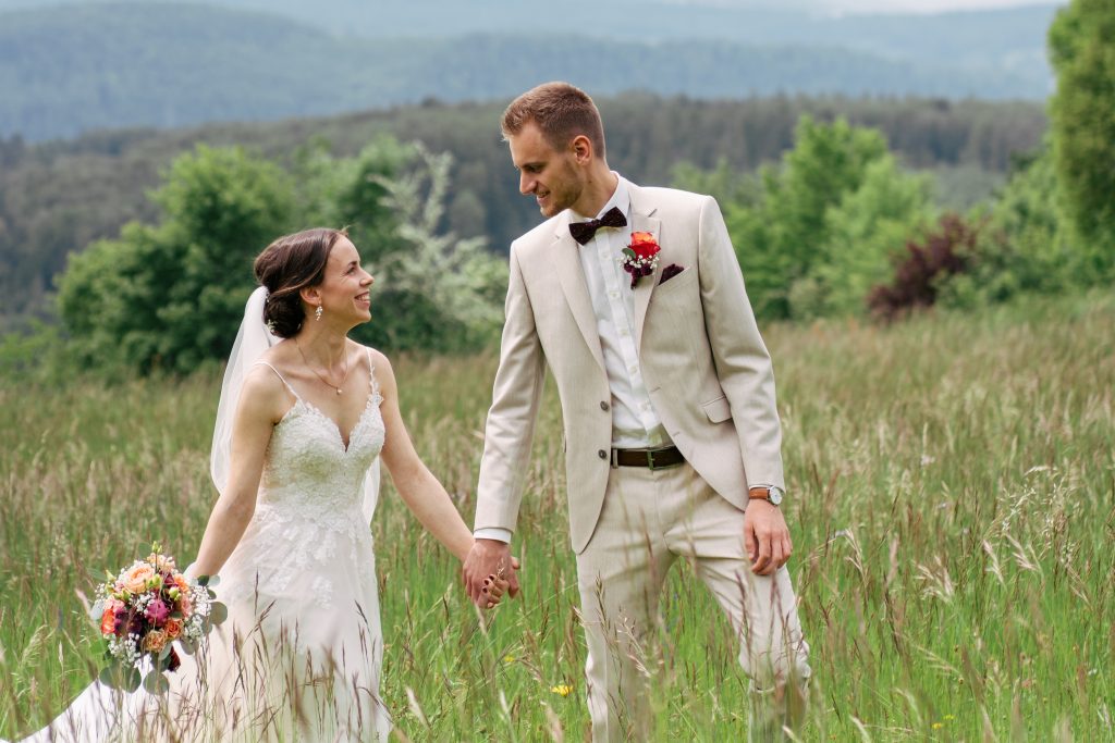 Brautpaar auf einer Bergwiese mit rotem Käfer – Hochzeitsfotografie Mosipictures