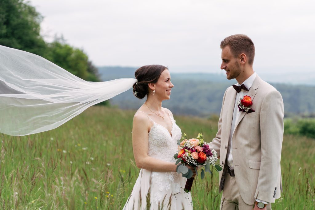 Brautpaar auf einer Bergwiese mit rotem Käfer – Hochzeitsfotografie Mosipictures