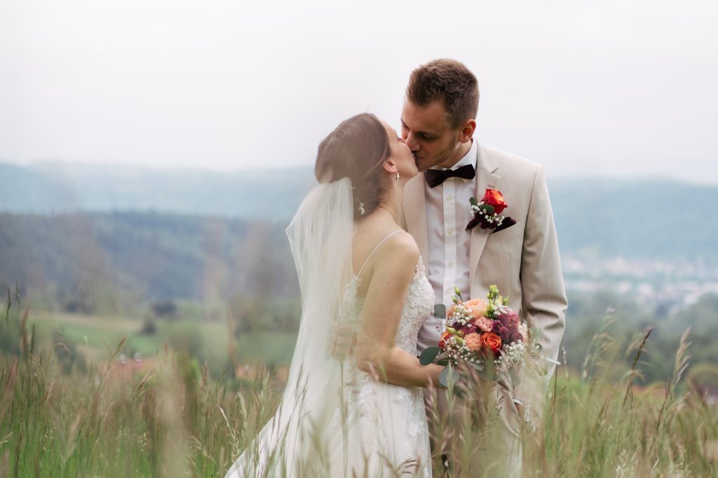 Brautpaar auf einer Bergwiese mit rotem Käfer – Hochzeitsfotografie Mosipictures