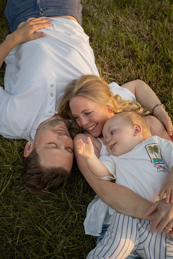 Familie liegt lachend im Gras – Familienshooting von Mosipictures