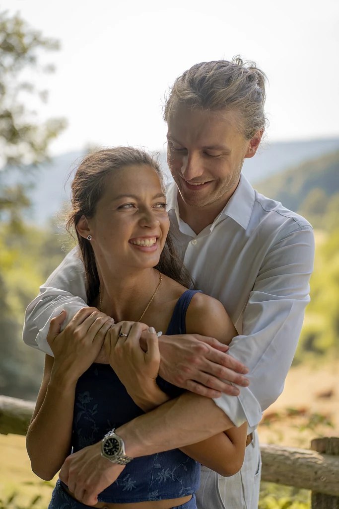 Mann umarmt seine Partnerin von hinten, beide lachen – Mosipictures