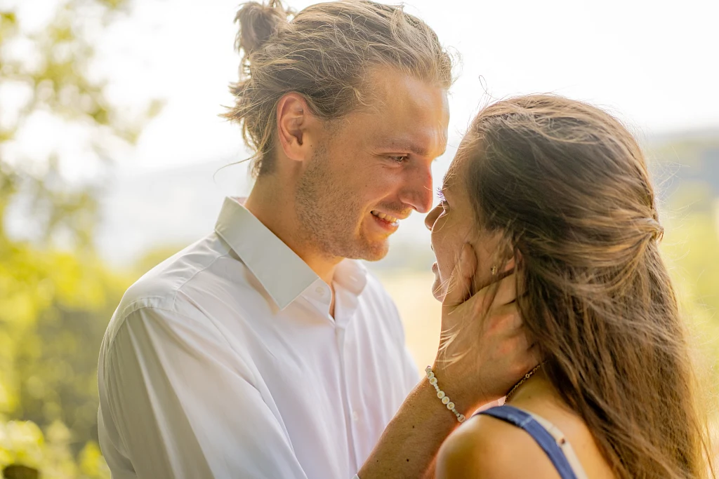 Mann hält zärtlich das Gesicht seiner Partnerin im Gegenlicht – Mosipictures